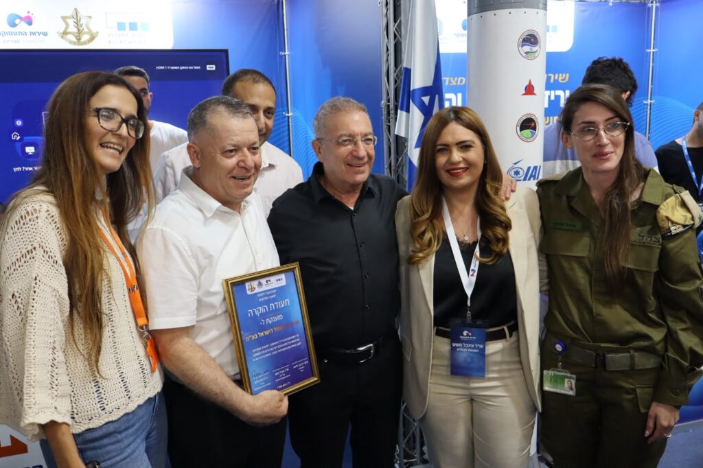 קבוצת משתתפים ובכירים ליד דוכן של שירות התעסוקה וצה"ל ביריד תעסוקה