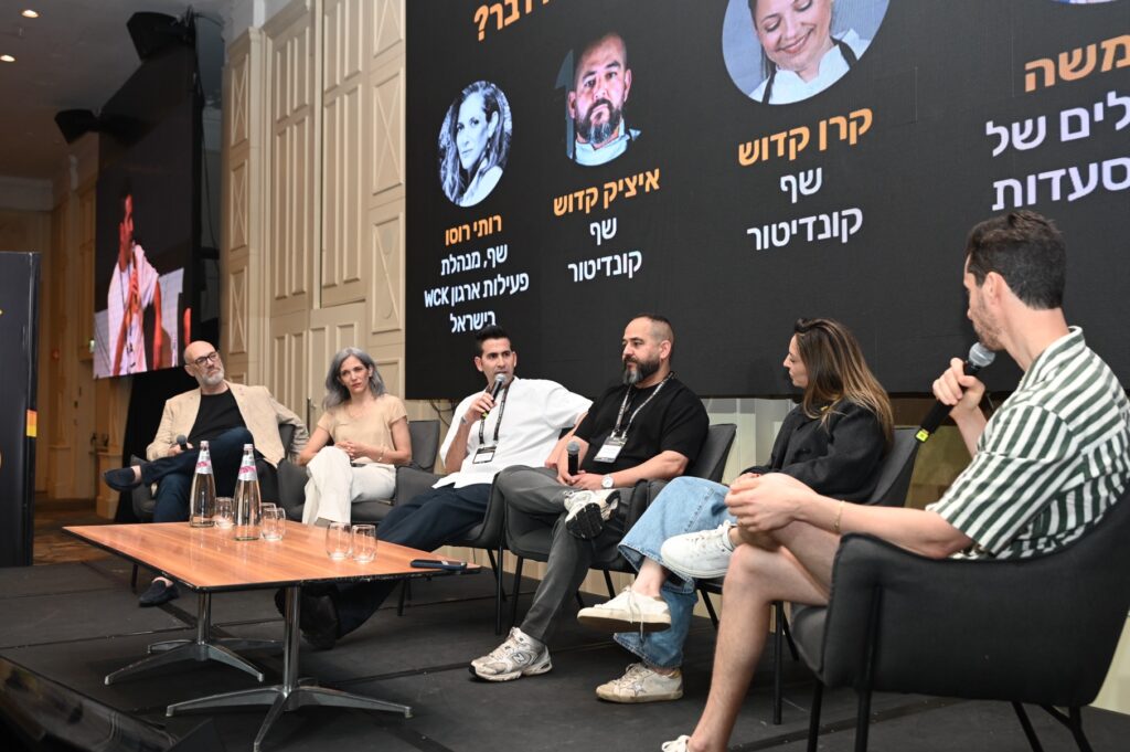 פאנל בכנס המסעדנות עם משתתפים יושבים על במה ומיקרופונים