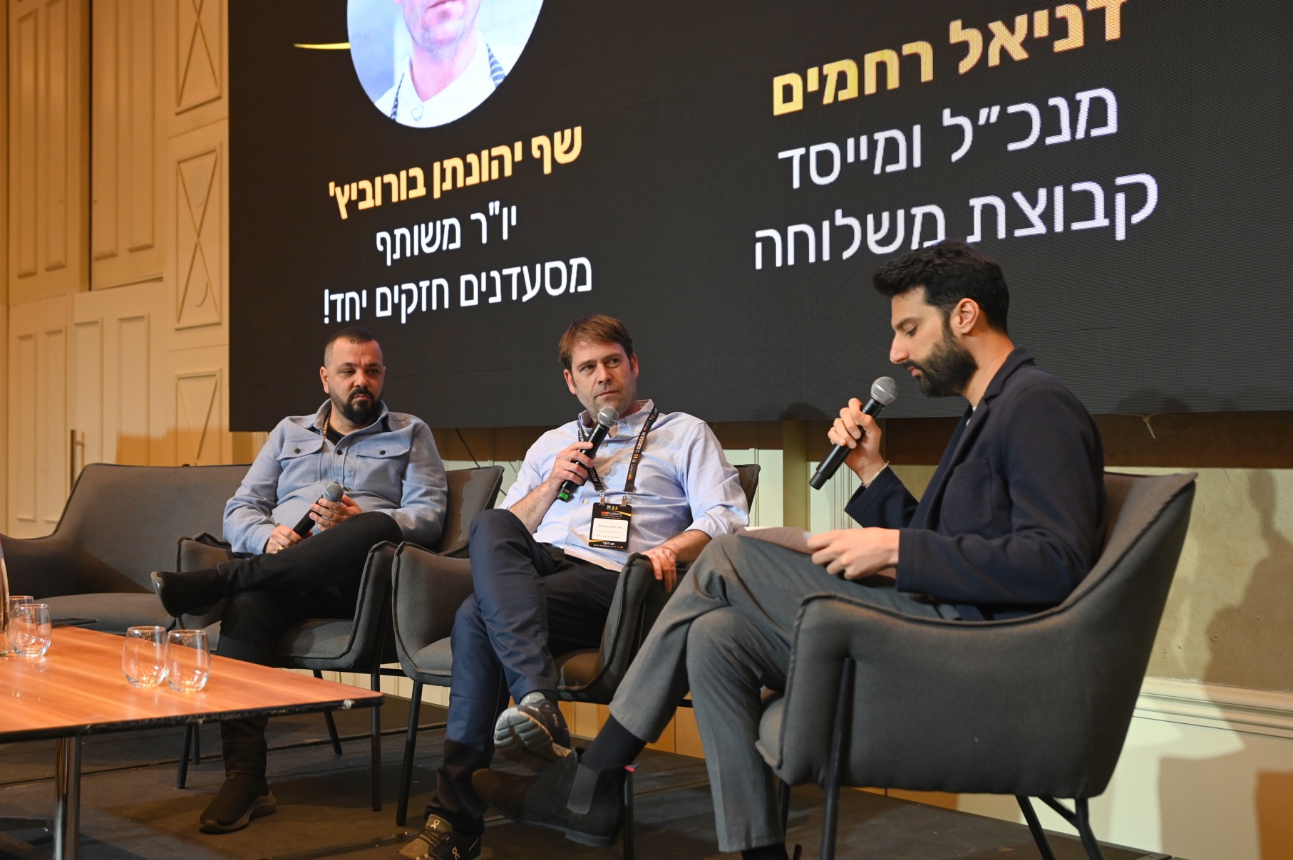 שלושה דוברים יושבים על במה בכנס המסעדנות