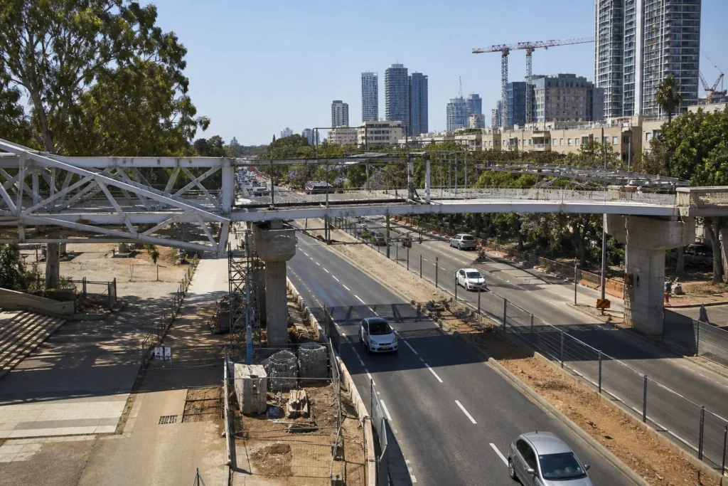 גשר הולכי רגל ואופניים בבנייה מעל שדרה עירונית רחבה