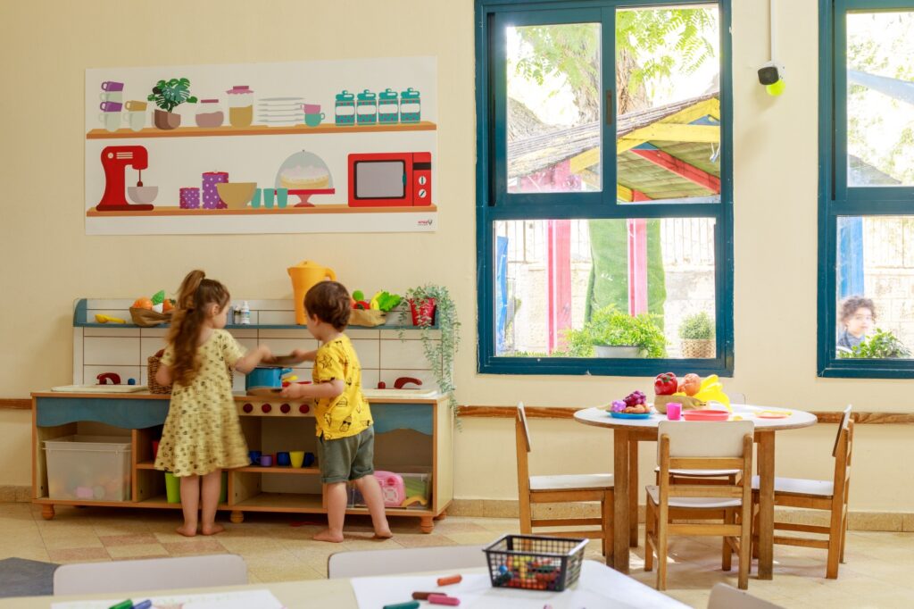 ילדים משחקים במטבח צעצוע בגן ילדים
