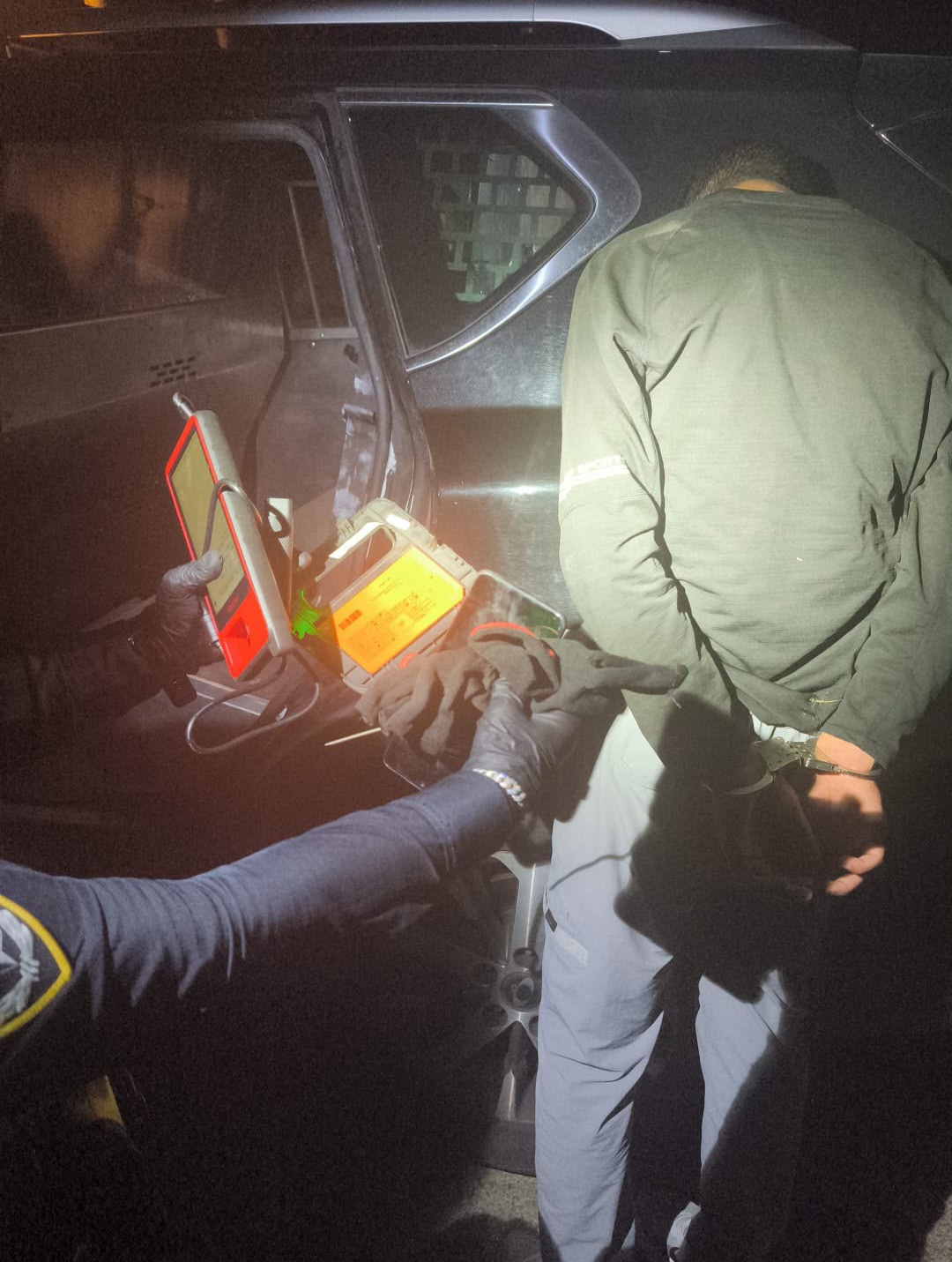 An officer beside a suspect arrested in Herzliya and seized equipment